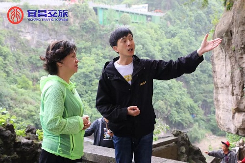 圖為向?。ㄗ蠖檠胍曋破?、主持人鞠萍（左一）介紹三游洞景區